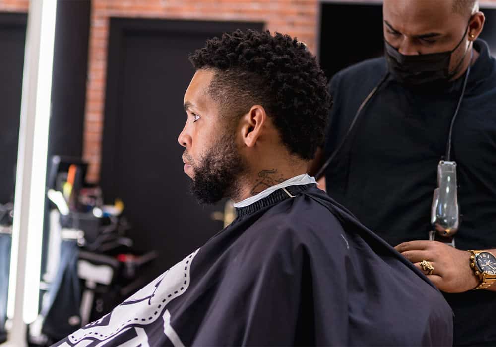 Afroglow barber preparing a client in the chair