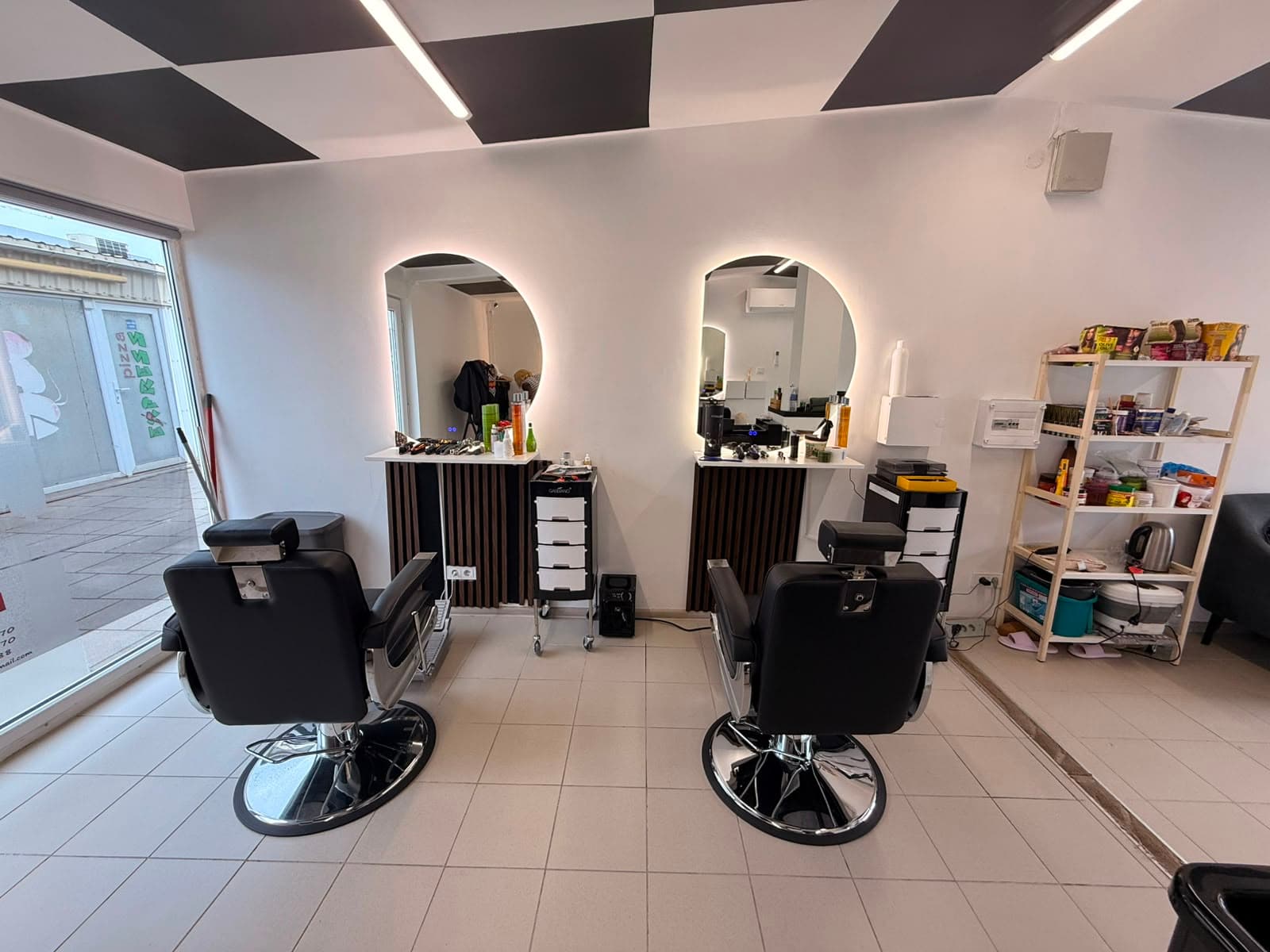 Afroglow studio interior in Vilnius — two barber stations with backlit mirrors